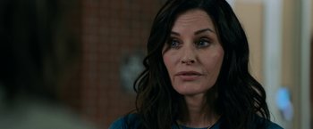 Movie still from “Scream” (2022), directed by Matt Bettinelli-Olpin – A person with long black hair; Close Up shot, Over the shoulder angle