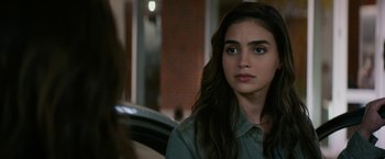 Movie still from “Scream” (2022), directed by Matt Bettinelli-Olpin – A woman with long brown hair sitting in front of a brick wall; Close Up shot, Over the shoulder angle