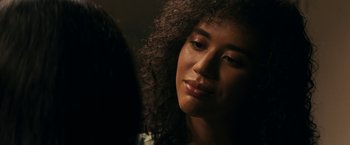 Movie still from “Scream” (2022), directed by Matt Bettinelli-Olpin – A person with curly brown hair; Close Up shot, Over the shoulder angle