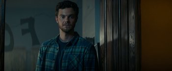 Movie still from “Scream” (2022), directed by Matt Bettinelli-Olpin – A man standing in front of a wooden door; Close Up shot, Over the shoulder angle