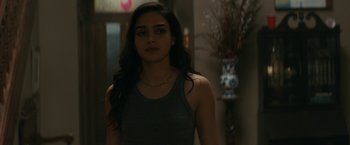 Movie still from “Scream” (2022), directed by Matt Bettinelli-Olpin – A woman standing in front of a vase in a room; Close Up shot, Over the shoulder angle