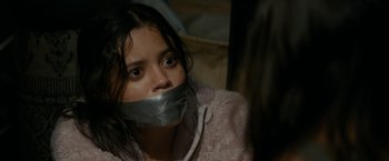 Movie still from “Scream” (2022), directed by Matt Bettinelli-Olpin – A young girl with duct tape around her mouth; Close Up shot, Over the shoulder angle