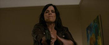 Movie still from “Scream” (2022), directed by Matt Bettinelli-Olpin – A woman holding a gun in a room; Close Up shot, Low angle