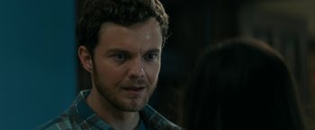 Movie still from “Scream” (2022), directed by Matt Bettinelli-Olpin – A person wearing a plaid shirt; Close Up shot, Over the shoulder angle