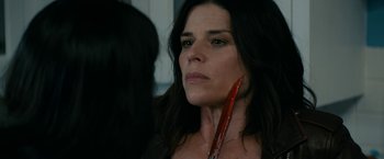 Movie still from “Scream” (2022), directed by Matt Bettinelli-Olpin – A person holding a red object in her mouth; Close Up shot, Over the shoulder angle