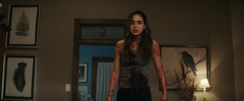 Movie still from “Scream” (2022), directed by Matt Bettinelli-Olpin – A woman with blood all over her face and arms; Medium shot, Over the shoulder angle