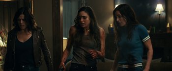 Movie still from “Scream” (2022), directed by Matt Bettinelli-Olpin – Two women are walking in a living room; Medium shot, Over the shoulder angle