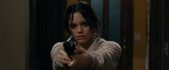 Movie still from “Scream” (2022), directed by Matt Bettinelli-Olpin – A woman holding a gun in her hand; Close Up shot, Over the shoulder angle