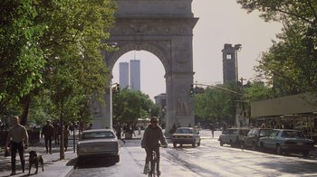 A man riding a bike down a street near tall buildings