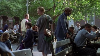 Movie still from “Searching for Bobby Fischer” (1993), directed by Steven Zaillian – A group of people sitting on benches near a tree; Wide shot, Over the shoulder angle
