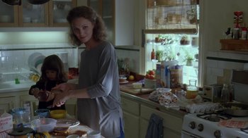Movie still from “Searching for Bobby Fischer” (1993), directed by Steven Zaillian – A woman standing in a kitchen preparing food; Medium shot, Low angle