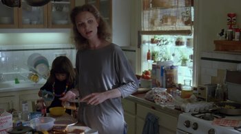 Movie still from “Searching for Bobby Fischer” (1993), directed by Steven Zaillian – A woman standing in a kitchen preparing a sandwich; Medium shot, Low angle