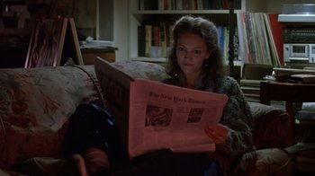 Movie still from “Searching for Bobby Fischer” (1993), directed by Steven Zaillian – A woman sitting on a couch reading a newspaper; Medium shot, High angle