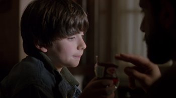 Movie still from “Searching for Bobby Fischer” (1993), directed by Steven Zaillian – A young boy is holding a glass of soda; Close Up shot, Over the shoulder angle