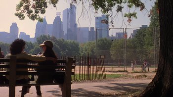 Movie still from “Searching for Bobby Fischer” (1993), directed by Steven Zaillian – A woman sitting on a bench in a park; Wide shot, Over the shoulder angle