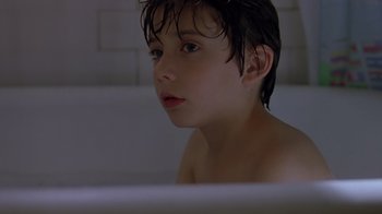 Movie still from “Searching for Bobby Fischer” (1993), directed by Steven Zaillian – A young boy sitting in a bath tub; Close Up shot, Low angle