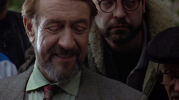 Movie still from “Searching for Bobby Fischer” (1993), directed by Steven Zaillian – A man in a suit and tie next to another man in glasses; Close Up shot, Over the shoulder angle