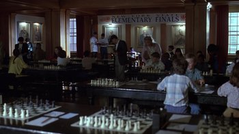 Movie still from “Searching for Bobby Fischer” (1993), directed by Steven Zaillian – A group of people standing around a table with chess pieces; Wide shot, High angle