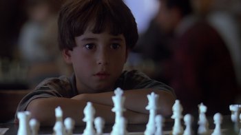 Movie still from “Searching for Bobby Fischer” (1993), directed by Steven Zaillian – A young boy sitting in front of a chess board; Close Up shot, High angle