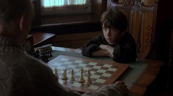 Movie still from “Searching for Bobby Fischer” (1993), directed by Steven Zaillian – A boy sitting at a table playing a game of chess; Close Up shot, Over the shoulder angle