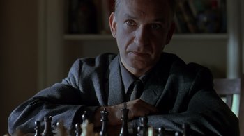 Movie still from “Searching for Bobby Fischer” (1993), directed by Steven Zaillian – A man sitting at a chess board with his arms crossed; Close Up shot, High angle
