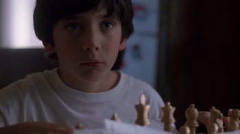 Movie still from “Searching for Bobby Fischer” (1993), directed by Steven Zaillian – A young boy is playing a game of chess; Close Up shot, Over the shoulder angle