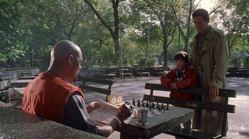 A man and a woman sitting at a table with chess pieces