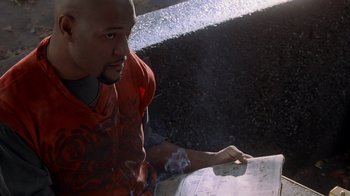Movie still from “Searching for Bobby Fischer” (1993), directed by Steven Zaillian – A man in a red shirt is holding a skateboard; Close Up shot, High angle