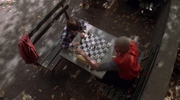 Movie still from “Searching for Bobby Fischer” (1993), directed by Steven Zaillian – Two men playing a game of chess on a park bench; Wide shot, High angle