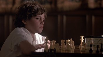 Movie still from “Searching for Bobby Fischer” (1993), directed by Steven Zaillian – A young boy is playing a game of chess; Close Up shot, Over the shoulder angle