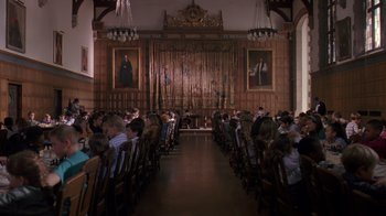 Movie still from “Searching for Bobby Fischer” (1993), directed by Steven Zaillian – People sitting in chairs in front of a wooden wall; Extreme Wide shot, High angle
