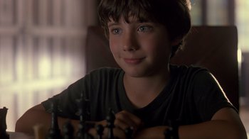 Movie still from “Searching for Bobby Fischer” (1993), directed by Steven Zaillian – A young boy sitting in front of a chessboard; Close Up shot, Over the shoulder angle