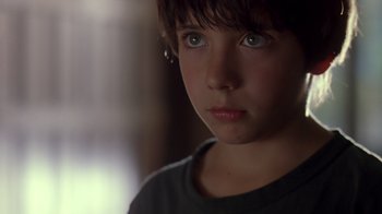 Movie still from “Searching for Bobby Fischer” (1993), directed by Steven Zaillian – A young boy is looking into the camera; Close Up shot, Over the shoulder angle