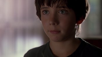 Movie still from “Searching for Bobby Fischer” (1993), directed by Steven Zaillian – A young boy with blue eyes stares into the camera; Close Up shot, Over the shoulder angle