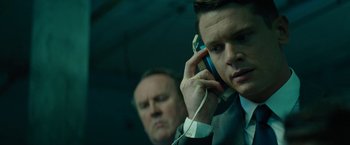 Movie still from “Seberg” (2019), directed by Benedict Andrews – A man talking on a cell phone next to another man; Close Up shot, Low angle