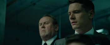 Movie still from “Seberg” (2019), directed by Benedict Andrews – Two men in business suits are looking at something; Close Up shot, Low angle