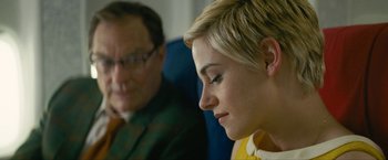 Movie still from “Seberg” (2019), directed by Benedict Andrews – A man and a woman sitting next to each other on a train; Close Up shot, Over the shoulder angle