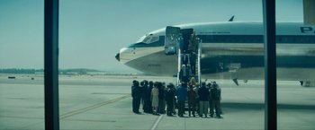 Movie still from “Seberg” (2019), directed by Benedict Andrews – A group of people standing on the steps of an airplane; Extreme Wide shot, High angle