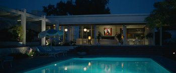 Movie still from “Seberg” (2019), directed by Benedict Andrews – A swimming pool in front of a building at night; Extreme Wide shot, Low angle