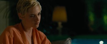 Movie still from “Seberg” (2019), directed by Benedict Andrews – A woman sitting on a couch in front of a lamp; Close Up shot, Over the shoulder angle