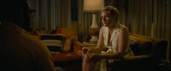 Movie still from “Seberg” (2019), directed by Benedict Andrews – A woman sitting in a chair holding a cigarette; Medium shot, Over the shoulder angle