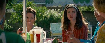 Movie still from “Seberg” (2019), directed by Benedict Andrews – Two women sitting at a table with drinks and food; Medium shot, Over the shoulder angle