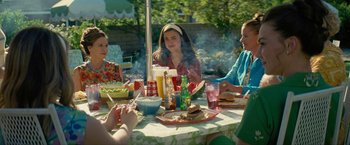 Movie still from “Seberg” (2019), directed by Benedict Andrews – A group of people sitting at a table with food on it; Medium shot, High angle