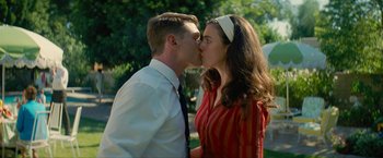 Movie still from “Seberg” (2019), directed by Benedict Andrews – A man and a woman kissing in a park; Medium shot, Low angle