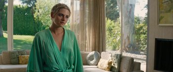 Movie still from “Seberg” (2019), directed by Benedict Andrews – A woman in a green robe standing in front of a window; Medium shot, Over the shoulder angle