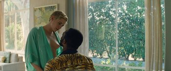 Movie still from “Seberg” (2019), directed by Benedict Andrews – A woman standing next to a man in front of a window; Medium shot, Over the shoulder angle