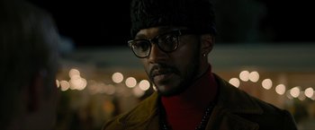 Movie still from “Seberg” (2019), directed by Benedict Andrews – A person wearing glasses and a hat; Close Up shot, Over the shoulder angle