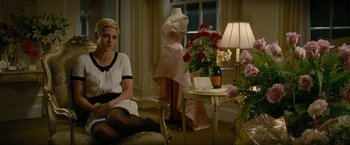 Movie still from “Seberg” (2019), directed by Benedict Andrews – A woman sitting on a chair next to a table; Medium shot, Over the shoulder angle