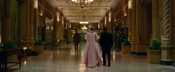 Movie still from “Seberg” (2019), directed by Benedict Andrews – A man and a woman walking down a hall way; Wide shot, Low angle