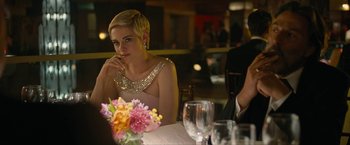 Movie still from “Seberg” (2019), directed by Benedict Andrews – A woman sitting at a table with a glass of wine; Medium shot, Over the shoulder angle